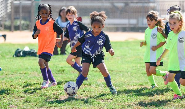 Region 13 girls chase the ball at a practice session